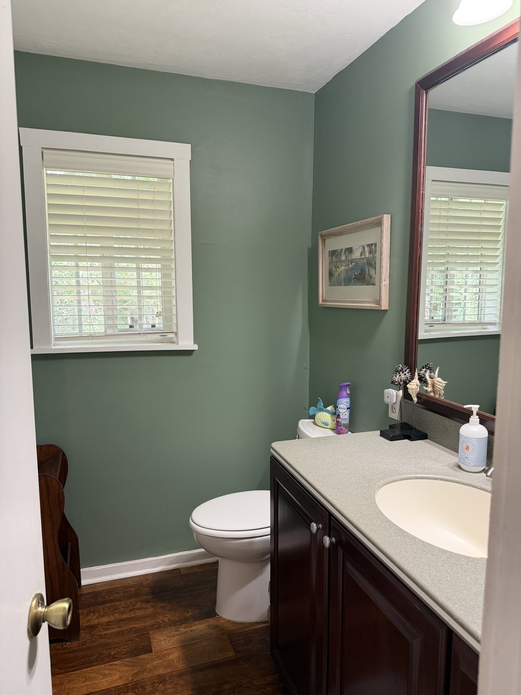 A half bath with a window looking out into the woods