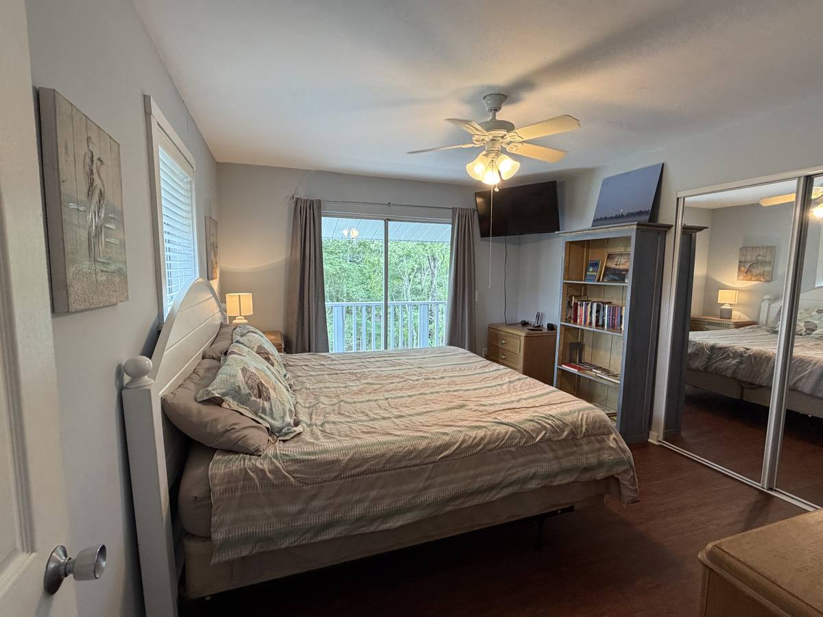 Third-floor bedroom with a king bed and a balcony over the woods