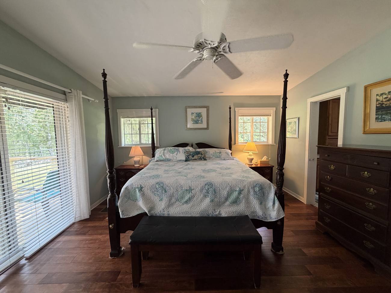 The master bedroom with a four-poster bed and windows to the river